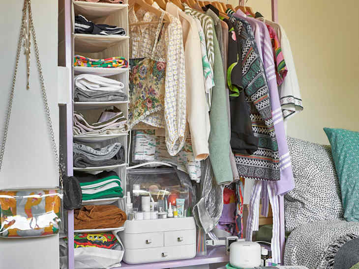 purple closet system with white organizers next to bed