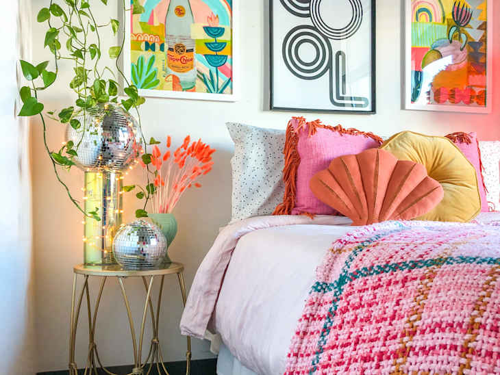 Pink colorful bed surrounded by art and plants