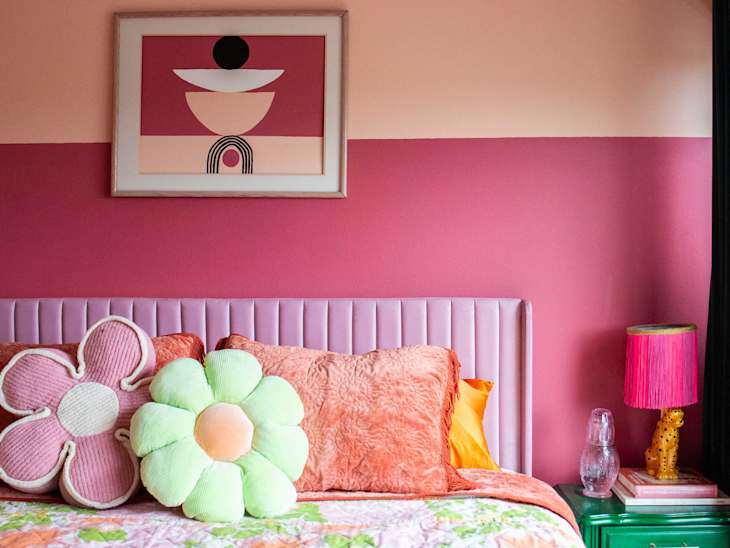 Neatly made bed in colorful bedroom.
