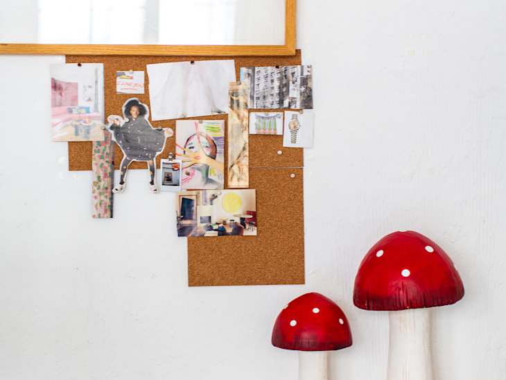 Mushroom sculptures on floor near inspiration board.