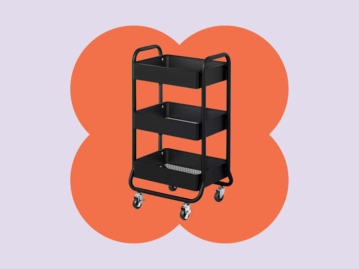 Black rolling cart with three shelves and wheels, set against a colorful background.