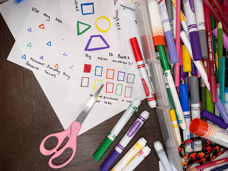Colorful markers and other crafting tools on table to make punch cards.
