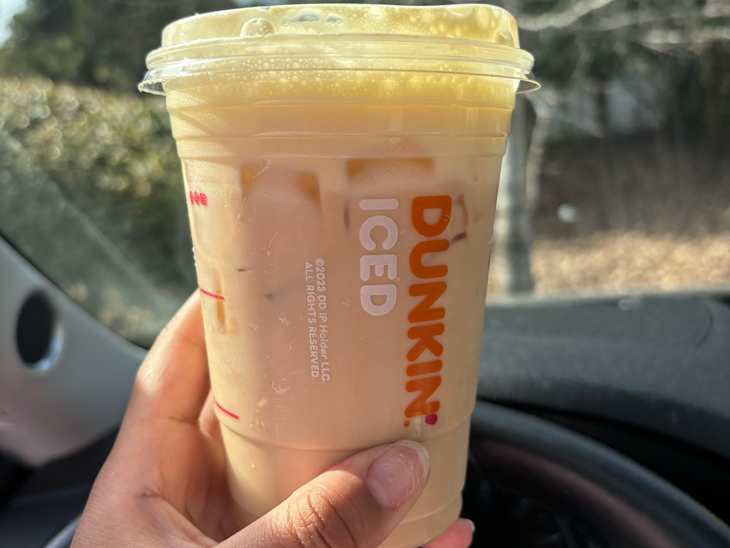 Someone holding a Dunkin banana cloud latte