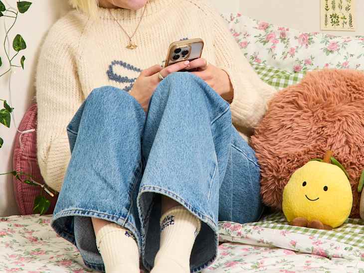 someone on their phone on a bed