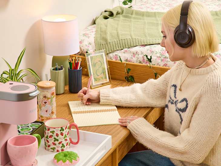 someone studying on a desk in cottage core dorm room