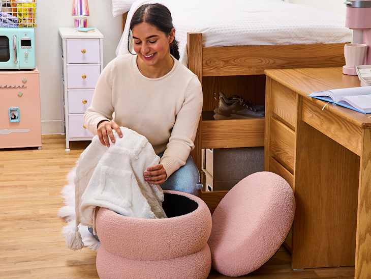 someone pulling a blanket out of an ottoman