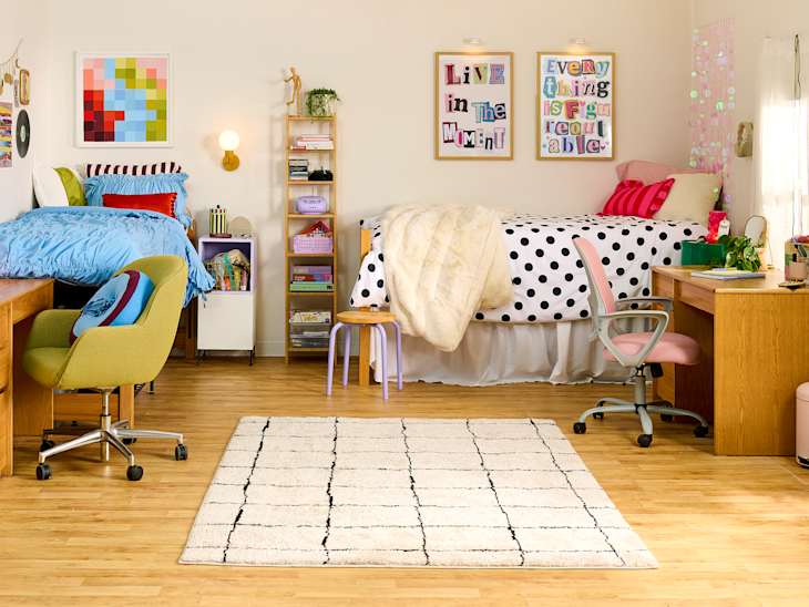 Colorful shared bedroom with two beds, a polka dot comforter, desks, and a patterned rug.