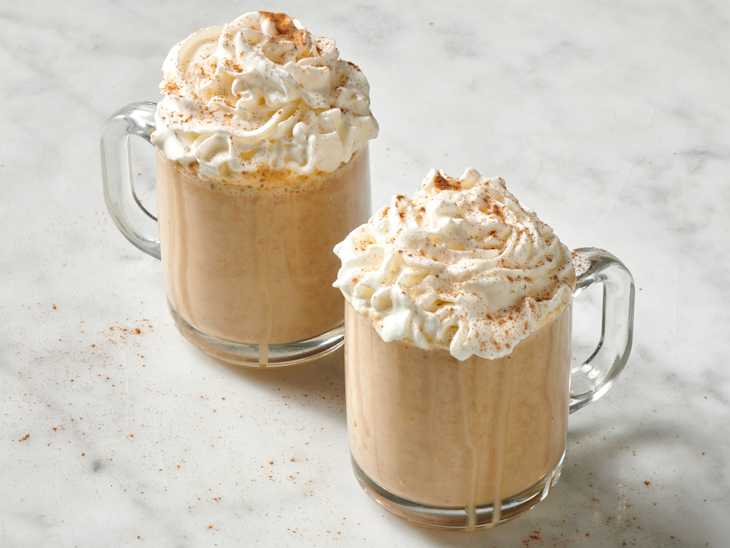 pumpkin spice lattes with whipped cream on marble surface