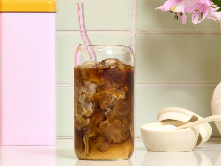 head on shot of iced coffee with milk on a kitchen counter