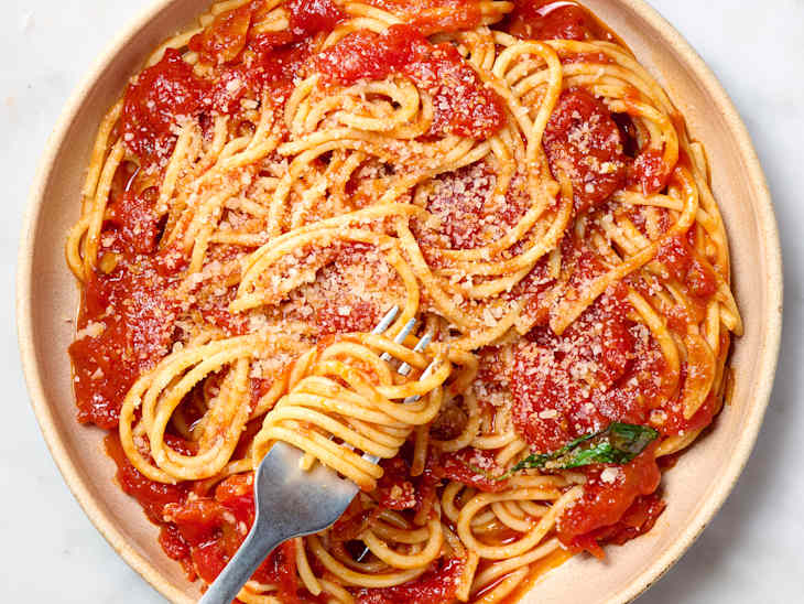 overhead shot of spaghetti marinara on a plate, topped with parmesan