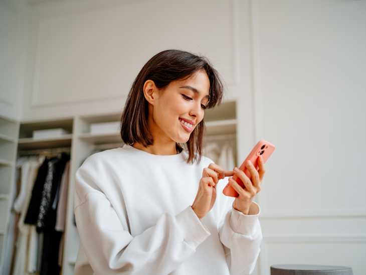 Woman using phone in bedroom.