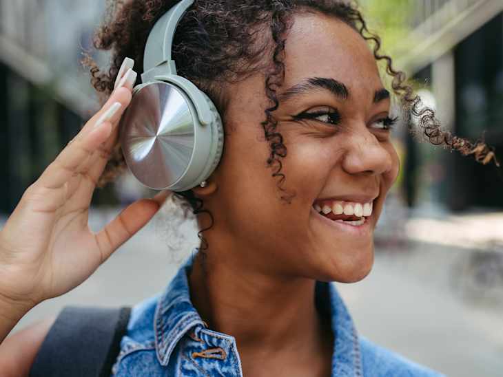 Young woman in the city with headphones on head.