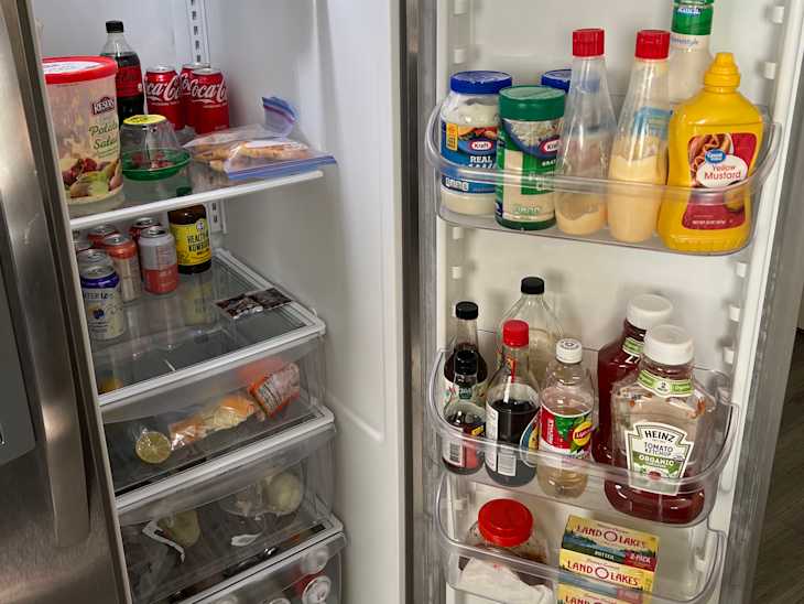 A well stocked refrigerator with various food items and beverages displayed clearly to provide a homey feel.