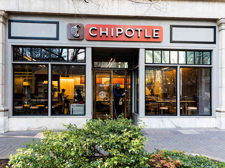 CHARLOTTE, NC, USA-26 JAN 2020: A Chipotle fast food restaurant in uptown Charlotte.  A man exits while two people sit inside.