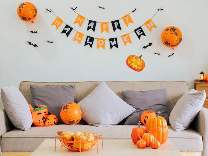 Halloween theme decorated living room. Lifestyle Halloween season family house interior. Traditional Halloween decorations background.