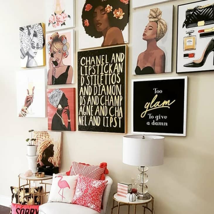Gallery wall with fashion-themed art, including portraits, quotes, and a high heel illustration, above a cozy seating area.