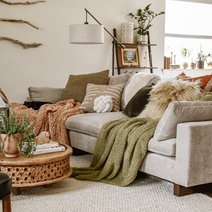 Gray sofa in living room with textured pillows and blankets