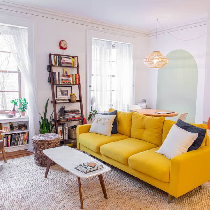 Living room with yellow sofa and colorful artwork