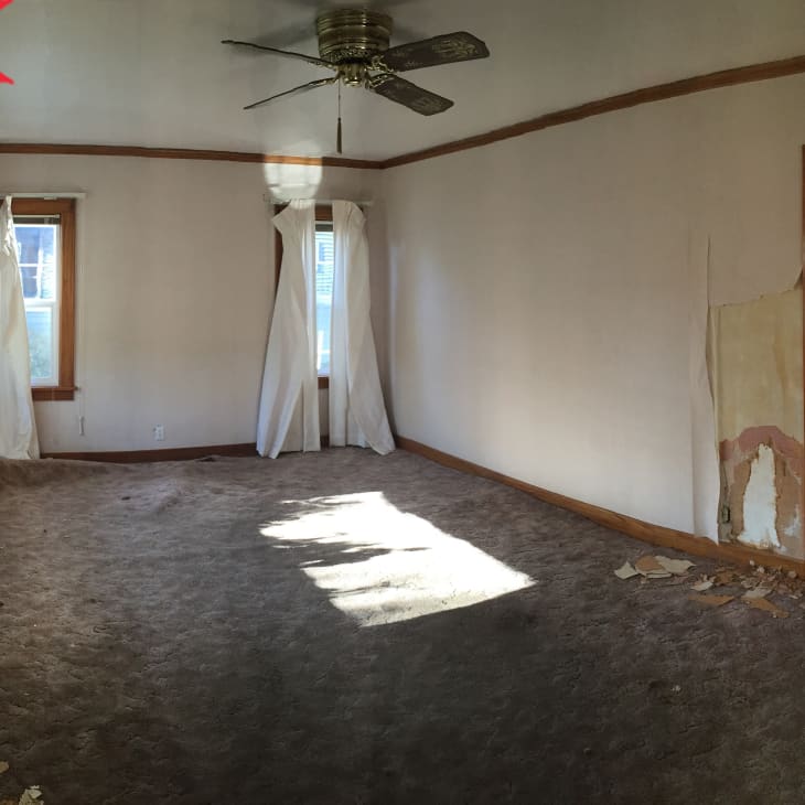Before: Living room with chipped walls and gray carpeting