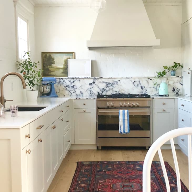Kitchen with marble backsplash, lamp, and red vintage rug