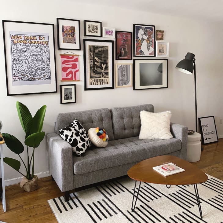 Gray sofa with patterned cushions, wooden coffee table, and eclectic gallery wall in a cozy living room.