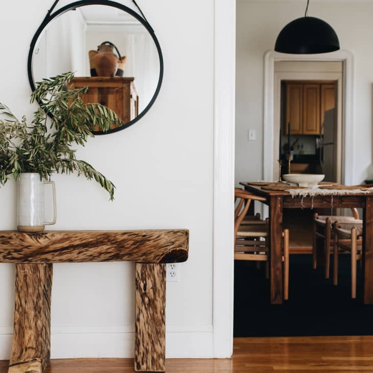 Console table beneath mirror and view of dining room to the right