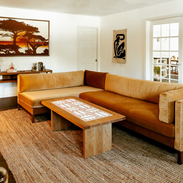 Large velvet sectional with light and dark tan cushions in neutral den
