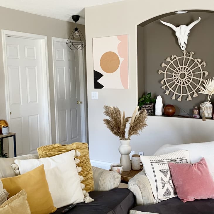 Bohemian styled living room with two white sofas and a ton of throw pillows