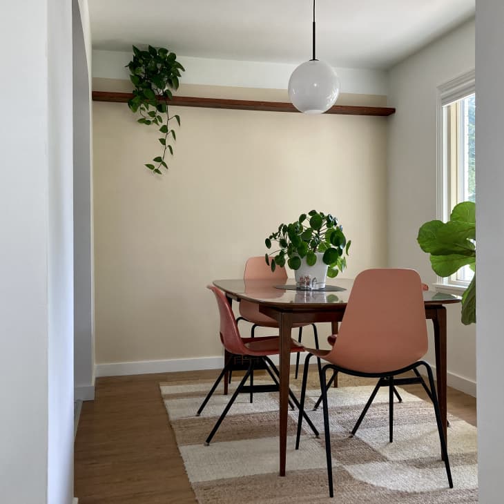 Dining room with peach-colored chairs, white spherical pendant light, and plants