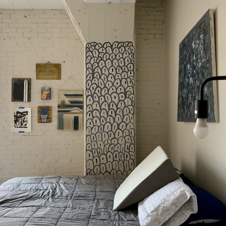 Bedroom with neutral color scheme, painted brick, and hand painted mural