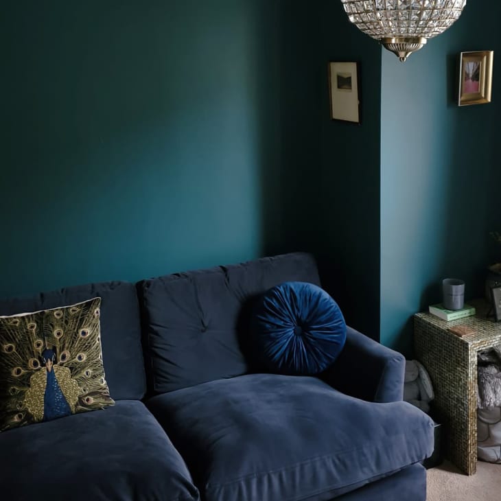 Living room with deep green walls and navy sofa