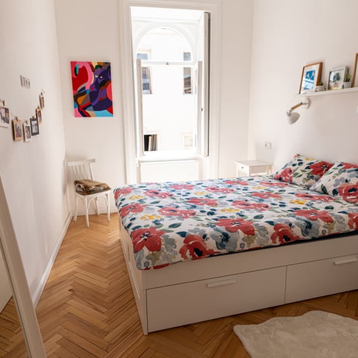 Bright bedroom with chevron wood floors and floral bedding