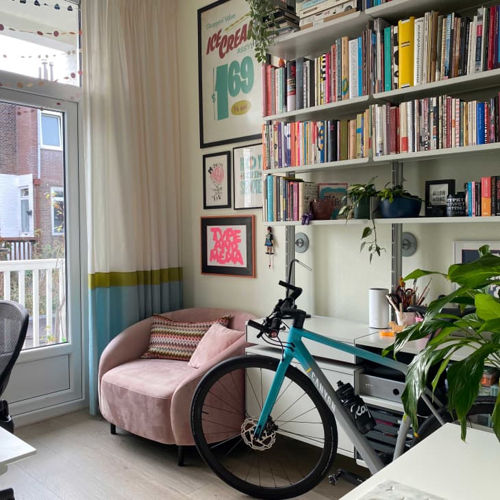 Office with books on bookshelf and bike in it