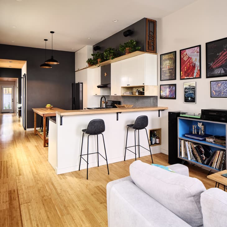 View of kitchen from living room in home with clean, straight lines