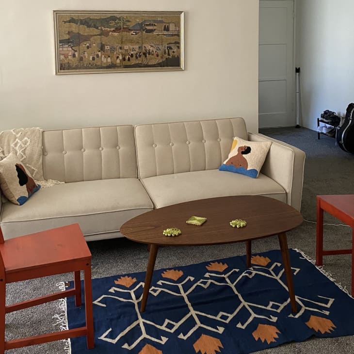 Living room with blue rug and two red chairs