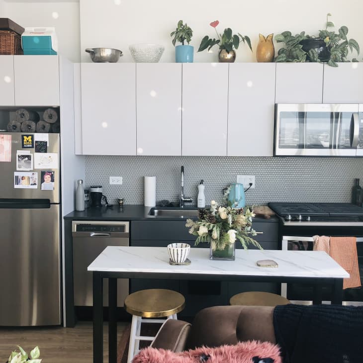 Small kitchen with items stored above cabinets