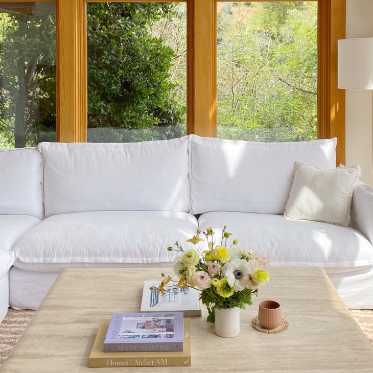 White sectional and square-shaped coffee table in room with large windows
