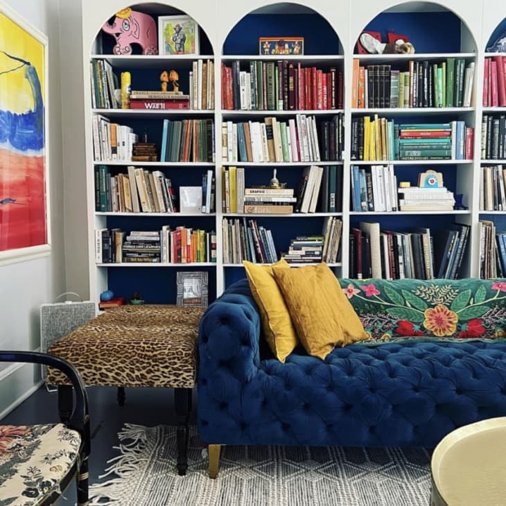 living room with 4 large built in bookcases and blue sofa
