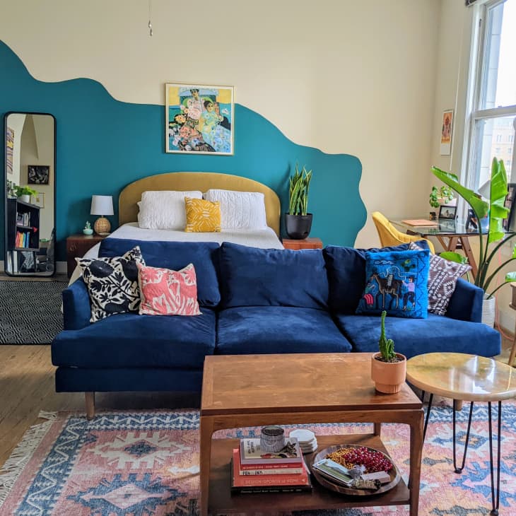 Living room and bedroom with colorful wall and rug