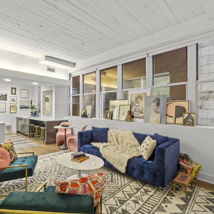 Living room with blue velvet couch and two green velvet chairs