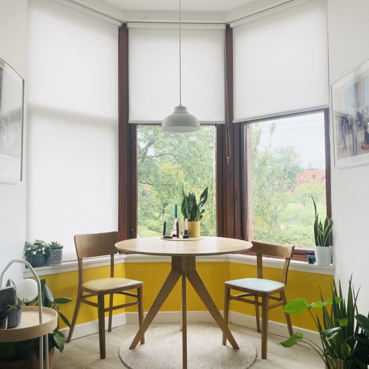 A dining table next to a bay window