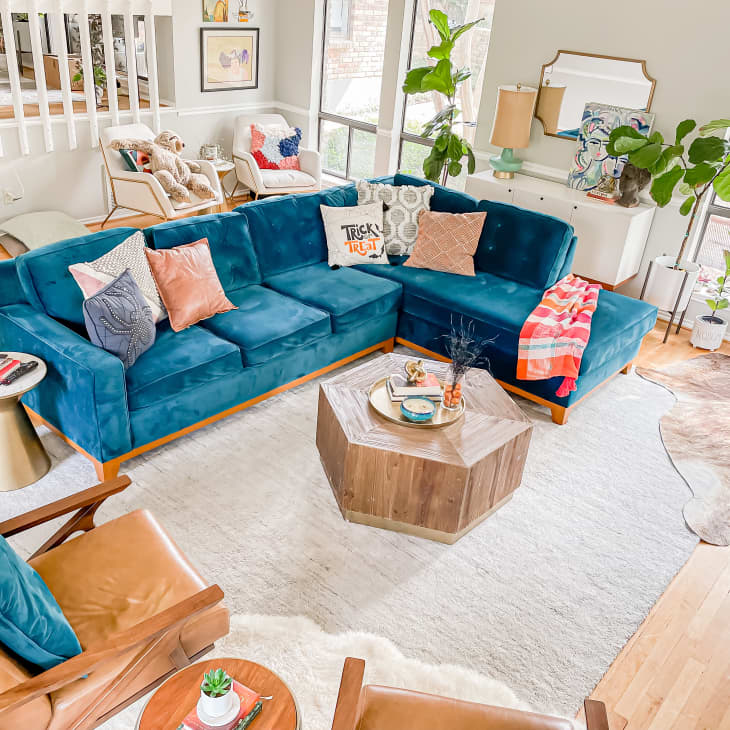 Blue sectional sofa in living room next to white rug and coffee table