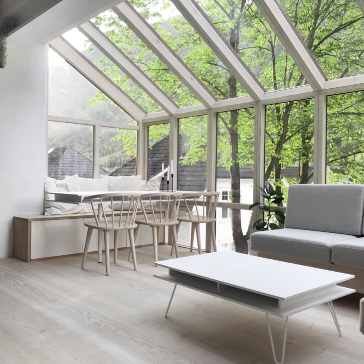 A living room with large windows on the walls and ceiling