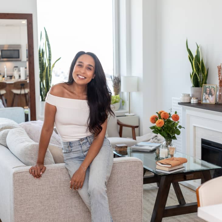 A woman leaning on a couch in a white living room