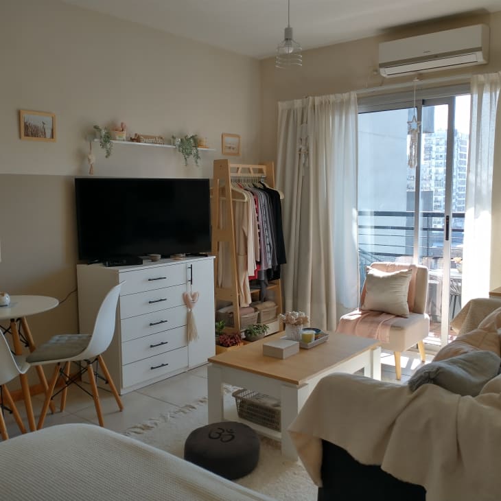 A studio apartment with a large couch facing a tv