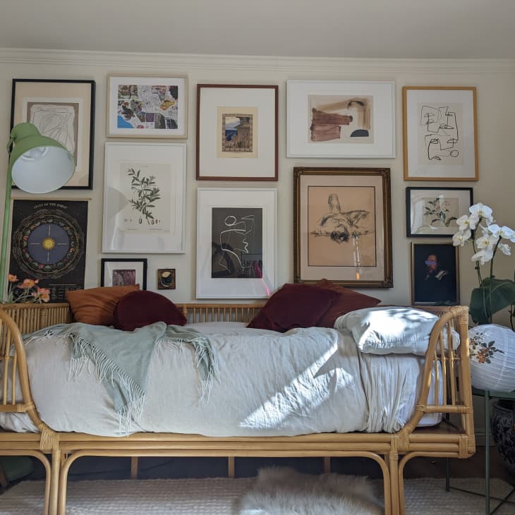 A large gallery wall with framed art above a daybed