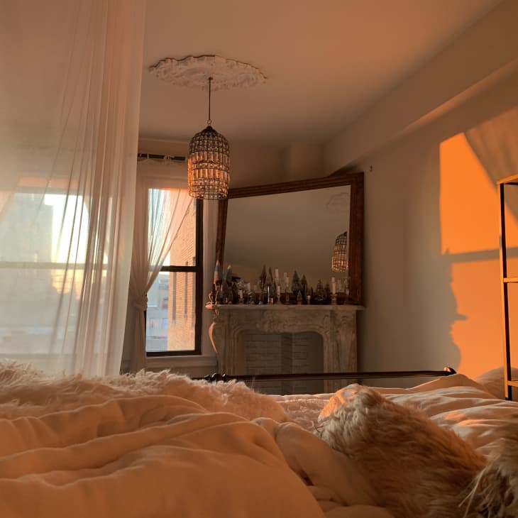 A bedroom with morning light coming in through sheer curtains