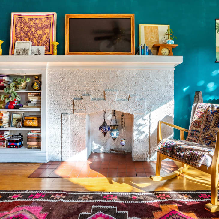Turquoise living room with white fireplace with built in shelves
