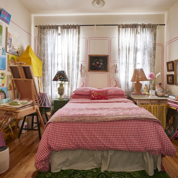 Gingham bedding in art filled bedroom.