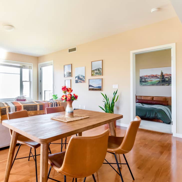 A dining room with a wooden table and tan chairs